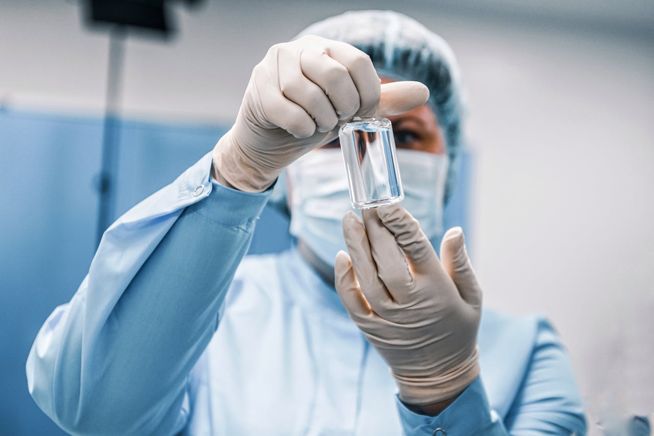 our-story Close-up of a healthcare worker in protective gear examining a medical vial.